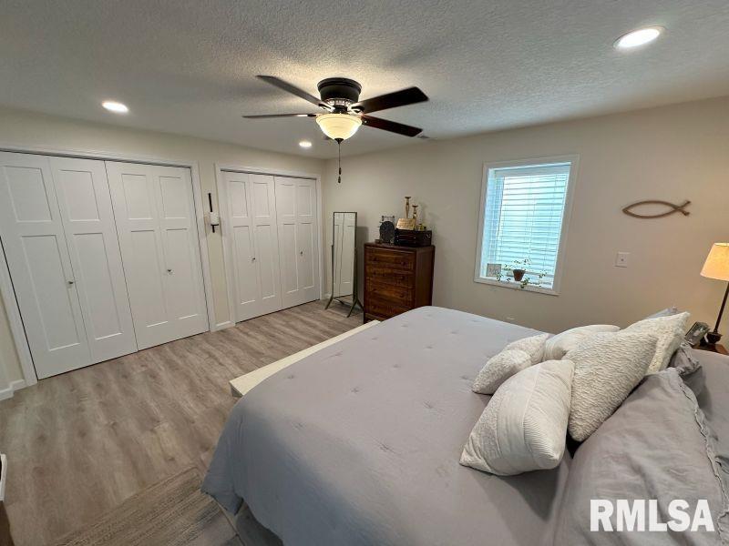 1144 Brookview Drive Dewitt, IA 52742 - Photo 24 of 28 a bedroom with a large bed and a chandelier