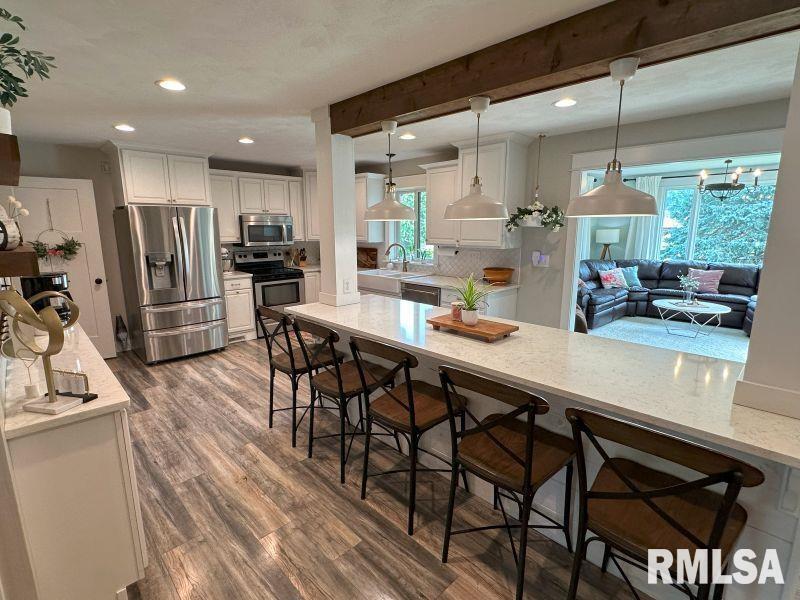 1144 Brookview Drive Dewitt, IA 52742 - Photo 10 of 28 a kitchen with stainless steel appliances kitchen island granite countertop a table chairs sink and cabinets