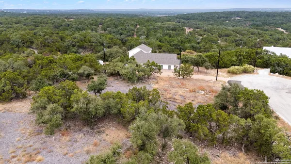an aerial view of a houses with a yard and mountain