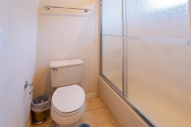 a white toilet sitting next to a shower