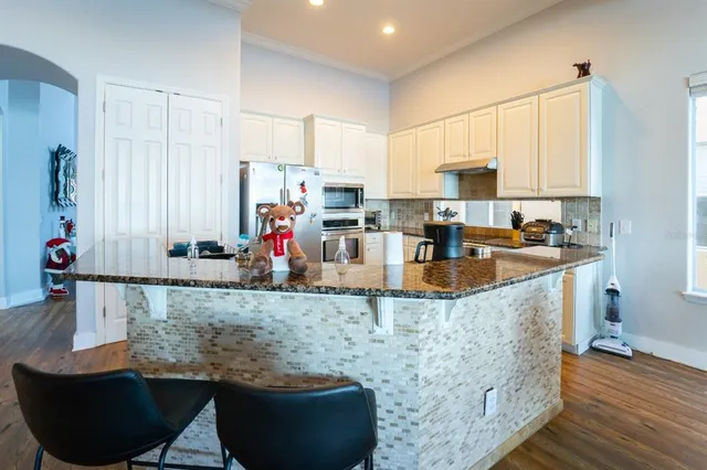 a kitchen with granite countertop a sink a stove and cabinets