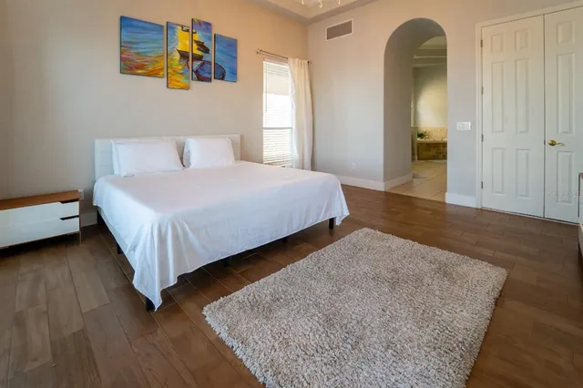 a bedroom with a bed and a painting on the wall