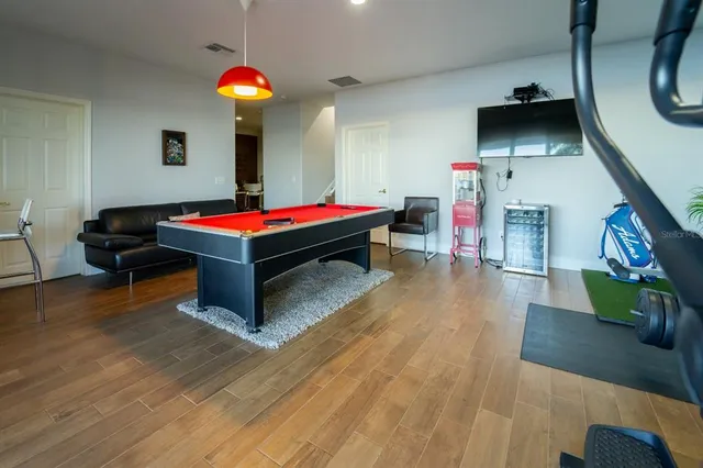 a living room with furniture and a pool table