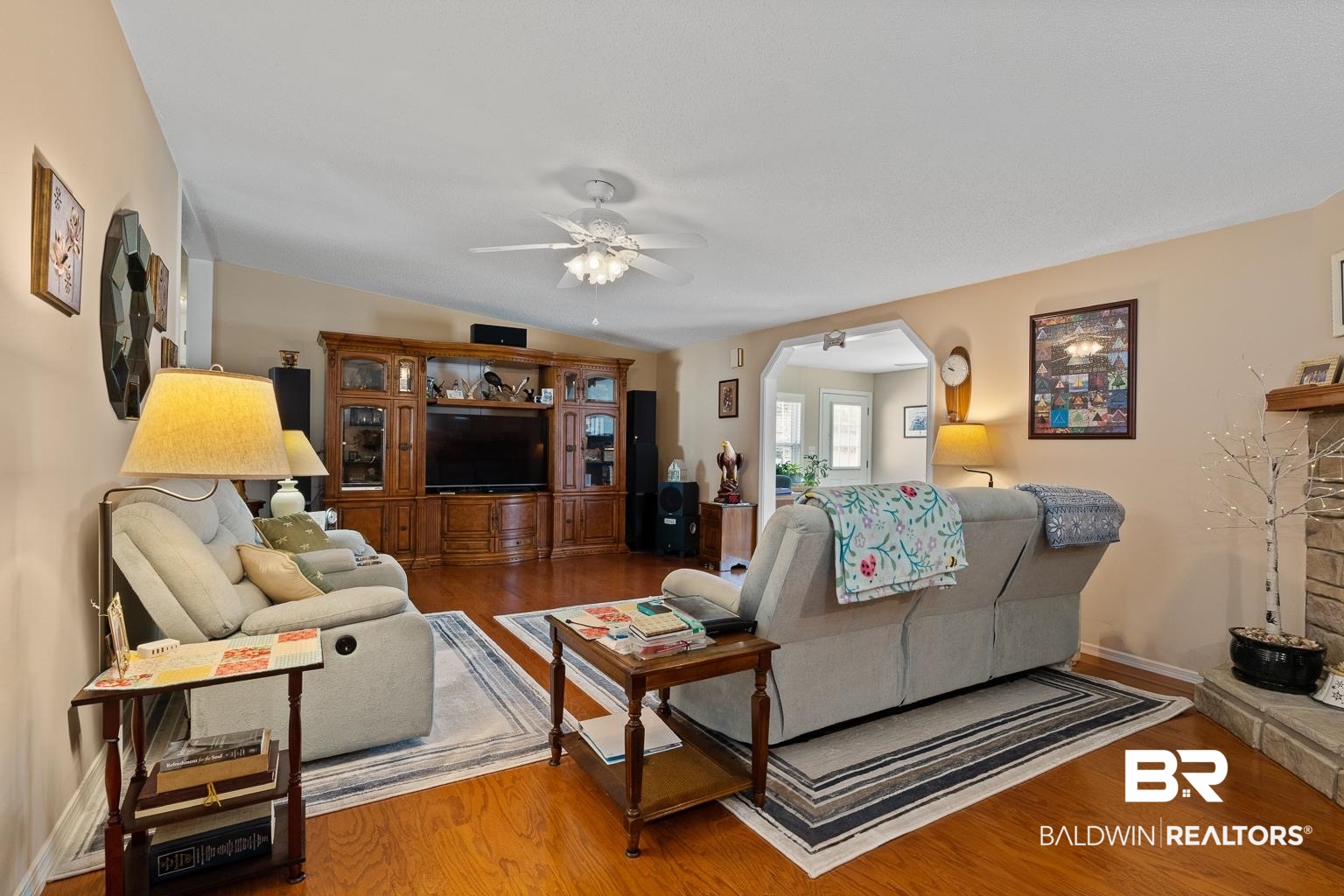 10647 Rte Road Lillian, AL 36549 - Photo 25 of 62 Living area featuring arched walkways, wood finished floors, a ceiling fan, and lofted ceiling