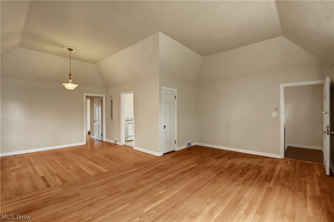 Upper unit view from living room towards dining room and kitchen, showing high ceilings