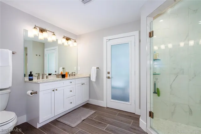 a spacious bathroom with a double vanity sink toilet and shower