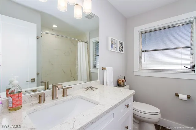 a bathroom with a sink vanity mirror and toilet