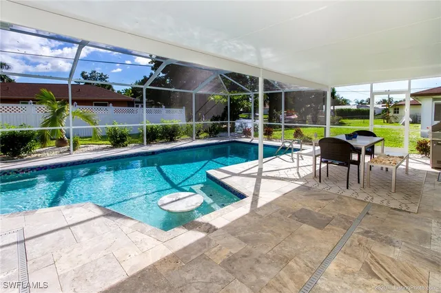 a view of a swimming pool with a patio and a garden
