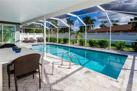 a living room with patio furniture and potted plants