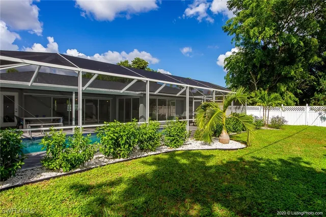 a view of a house with a big yard and potted plants