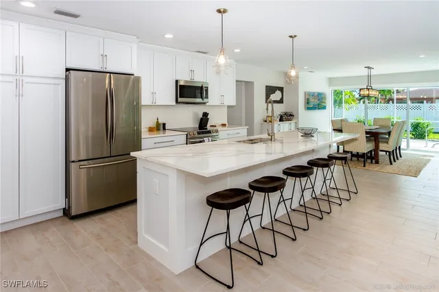 a kitchen with granite countertop a table chairs stove refrigerator and microwave