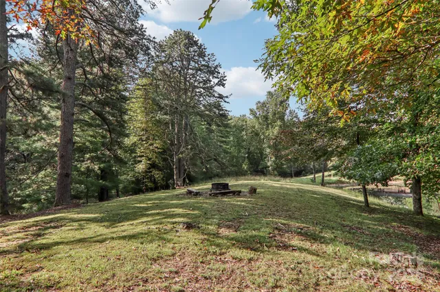 a view of a house with backyard and trees