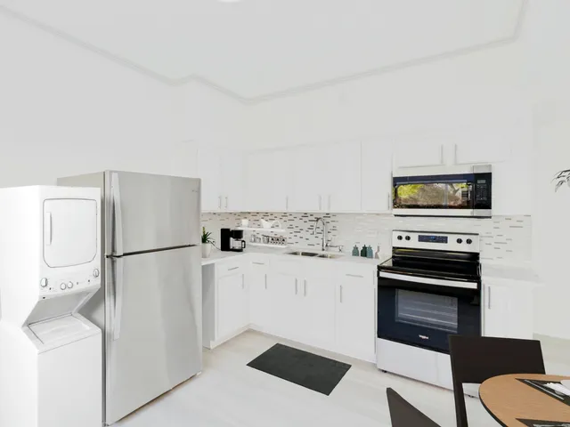 a kitchen with a refrigerator and a stove top oven