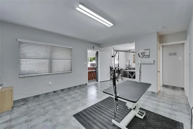 a room with gym equipment and wooden floor