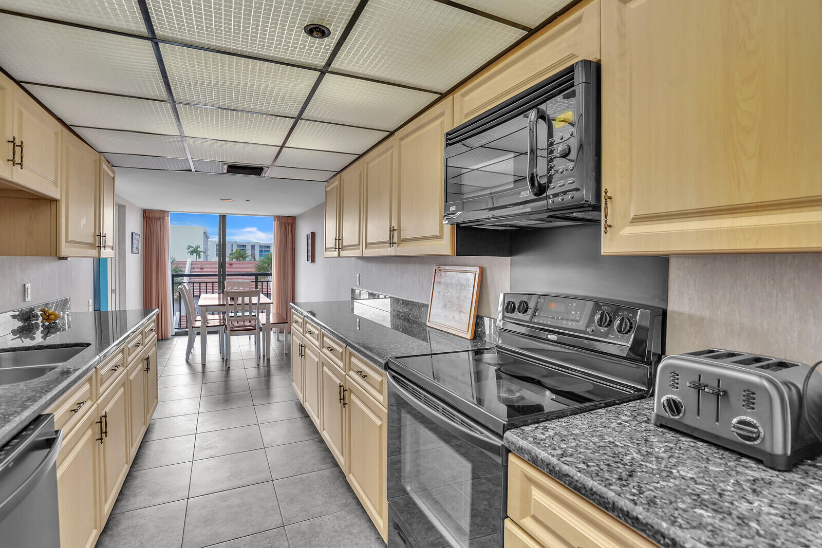 2667 North Ocean Boulevard, Unit I312 Boca Raton, FL 33431 - Photo 18 of 77 a kitchen with stainless steel appliances granite countertop a stove a sink and a microwave
