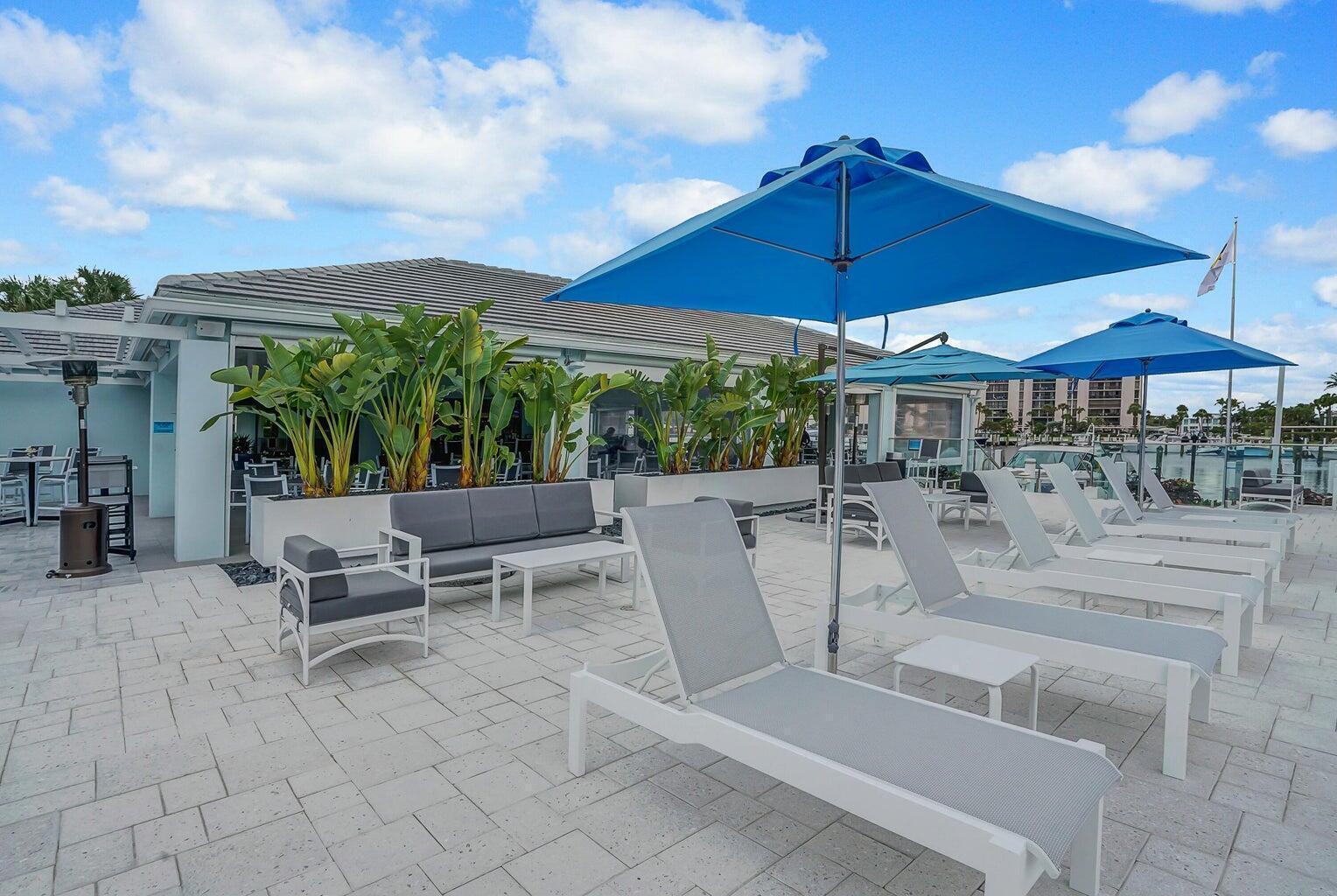 2667 North Ocean Boulevard, Unit I312 Boca Raton, FL 33431 - Photo 48 of 77 a view of a patio with a table and chairs under an umbrella