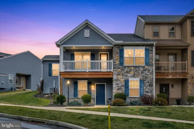 a front view of a brick house with a yard