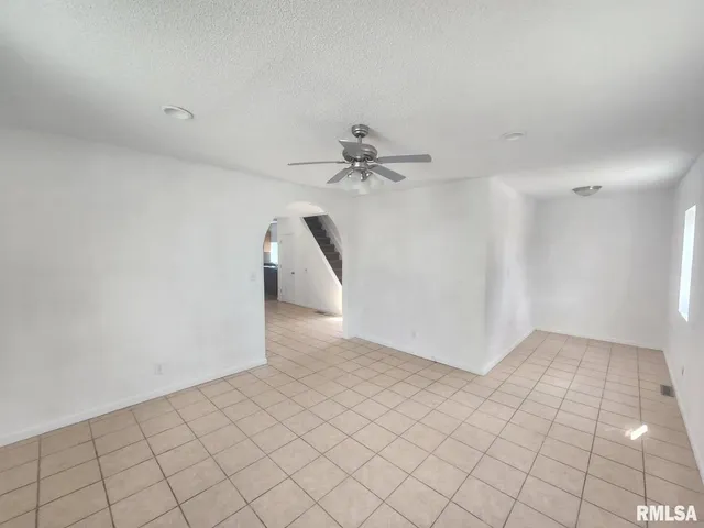 a view of a room with a ceiling fan and carpet