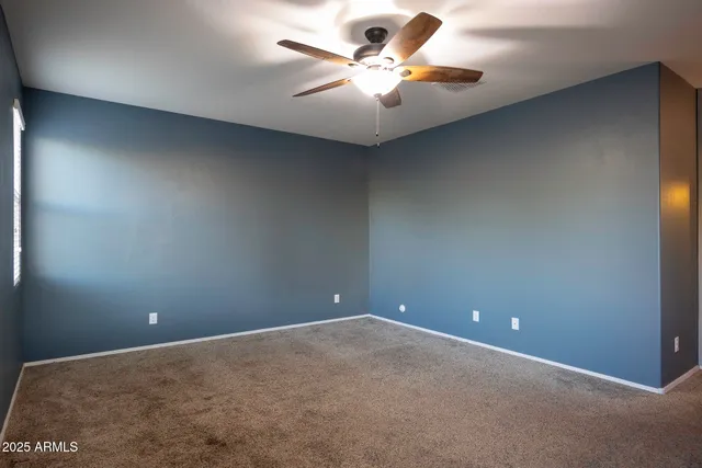 an empty room and chandelier fan