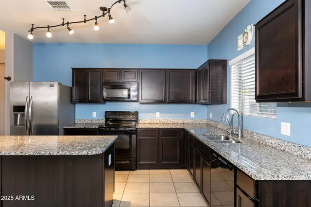a kitchen with a granite countertop sink and natural light