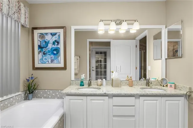 a bathroom with a granite countertop shower a sink and a mirror