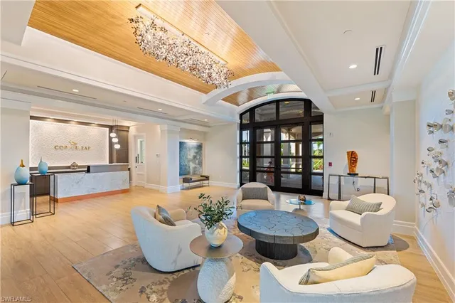 a living room with patio furniture and a chandelier