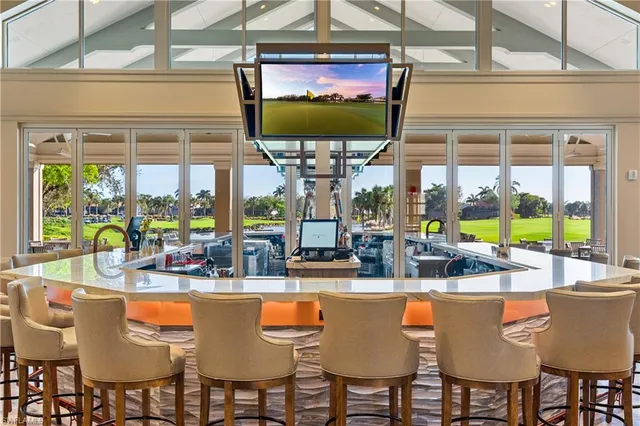 a room with lots of tables a large window and chairs