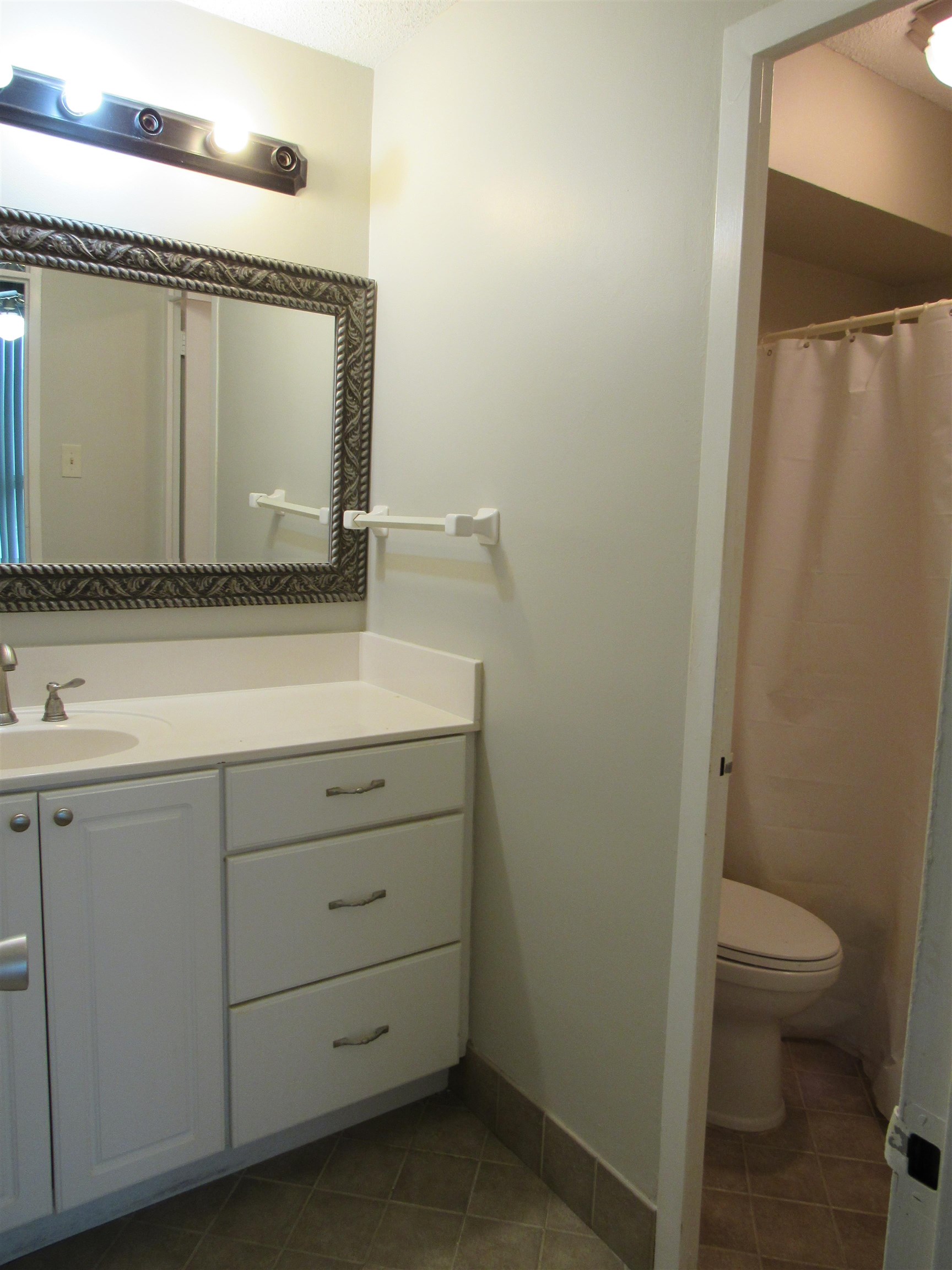 3080 Walnut Grove Road, Unit 205 Memphis, TN 38111 - Photo 19 of 26 a bathroom with a granite countertop sink a toilet and a mirror