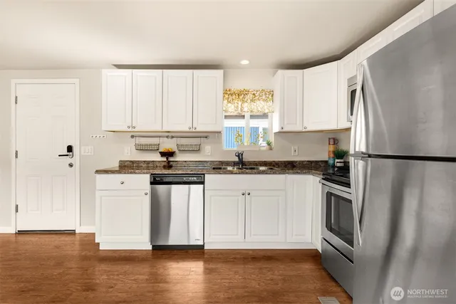 a kitchen with stainless steel appliances granite countertop a refrigerator sink and stove