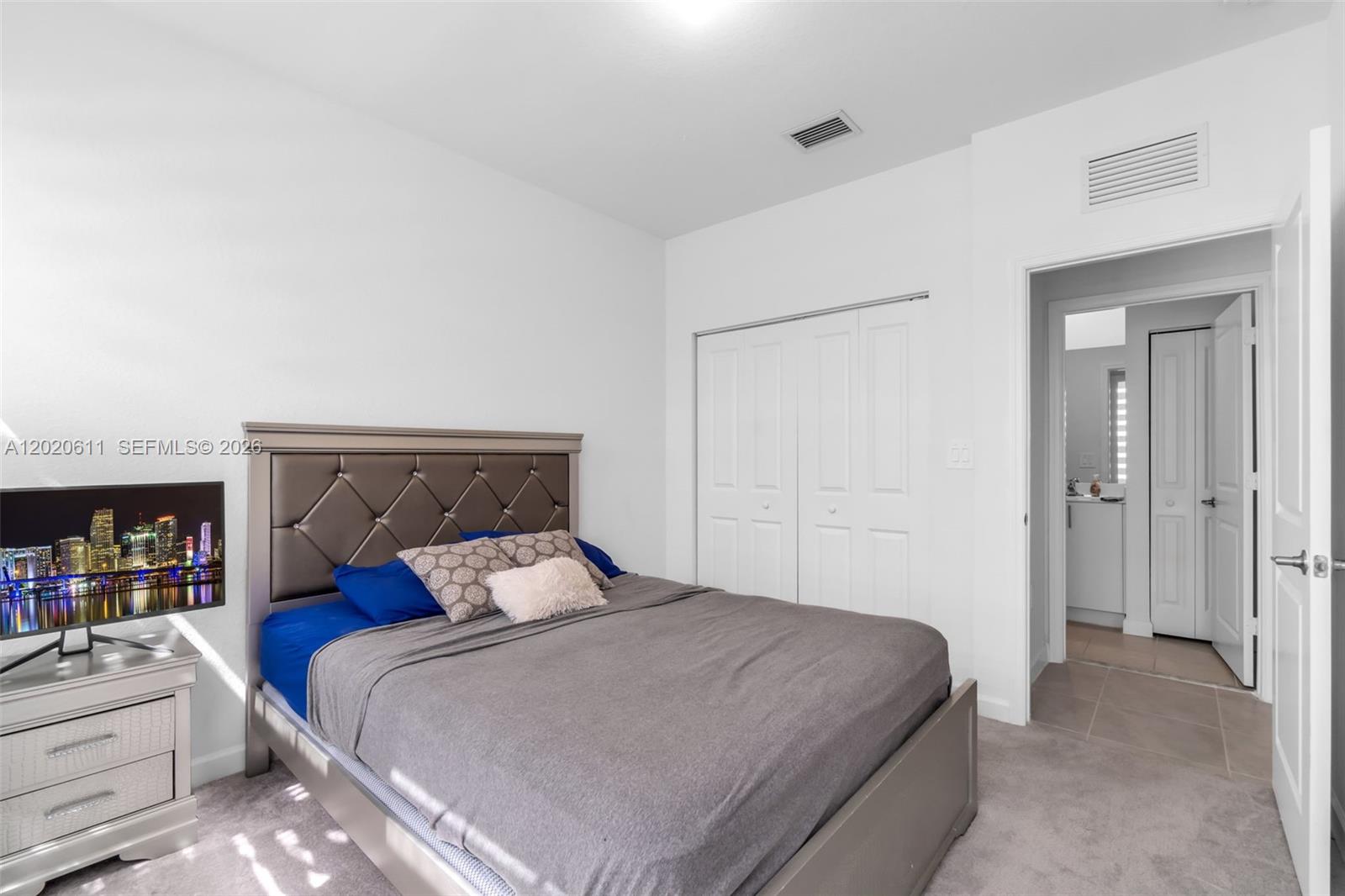 26455 Southwest 148th Avenue Homestead, FL 33032 - Photo 12 of 35 a bedroom with a large bed and a book shelf
