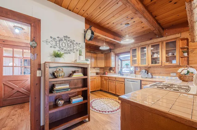 a kitchen with stainless steel appliances granite countertop a sink and cabinets with wooden floor