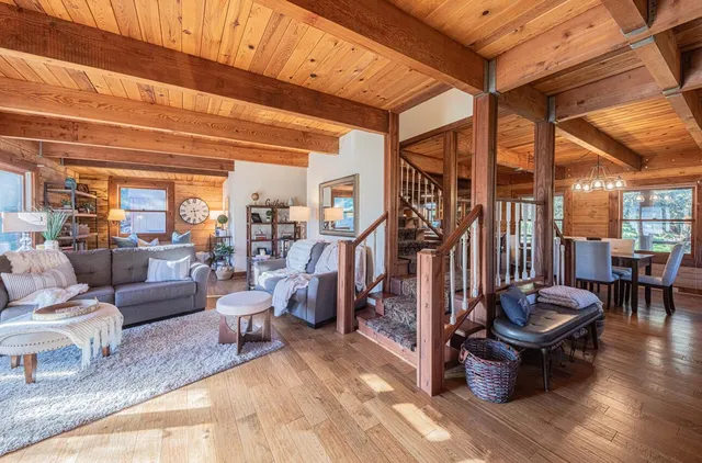 a living room with fireplace furniture and a large window