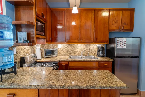 a kitchen with kitchen island granite countertop wooden cabinets a granite counter top and a sink