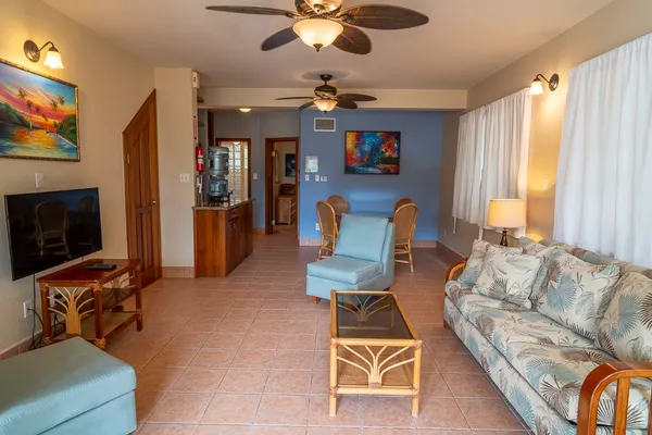 a living room with furniture a flat screen tv and a window