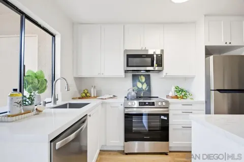 a kitchen with appliances a sink cabinets and a window