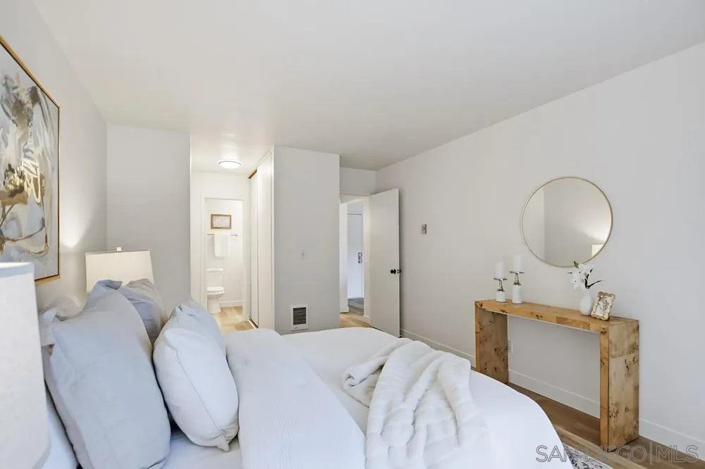 7858 Cowles Mountain Court, Unit D7 San Diego, CA 92119 - Photo 25 of 40 a bedroom with a bed mirror and a window