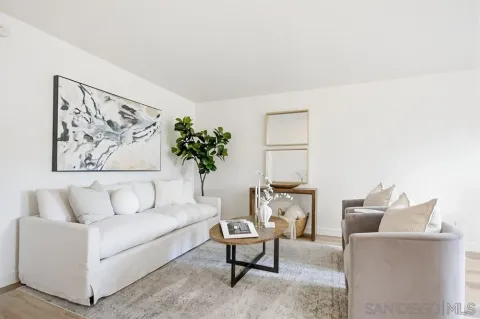 a living room with furniture and a painting on the wall
