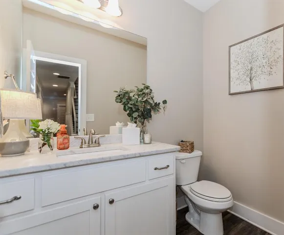 a living room with furniture wooden floor and a kitchen view