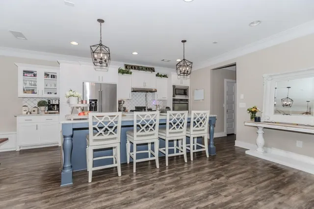 a dining room with furniture a chandelier and wooden floor