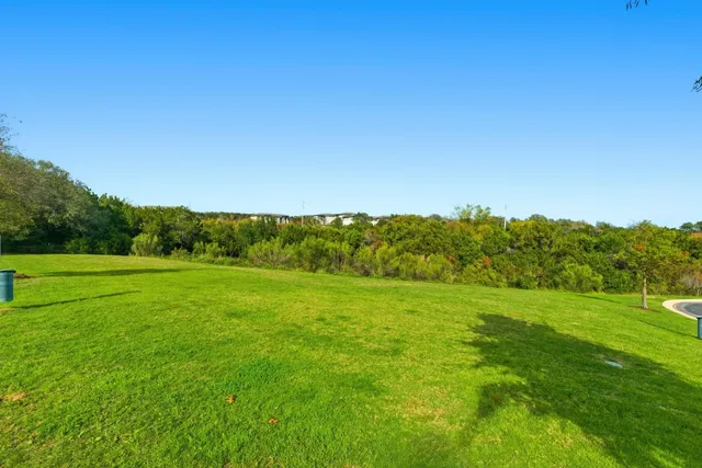 a view of a house with a big yard and potted plants