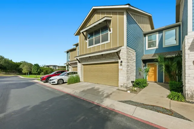 a front view of a house with a yard and parking space