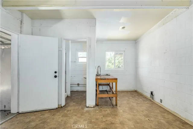a view of a hallway with wooden floor and a bathroom
