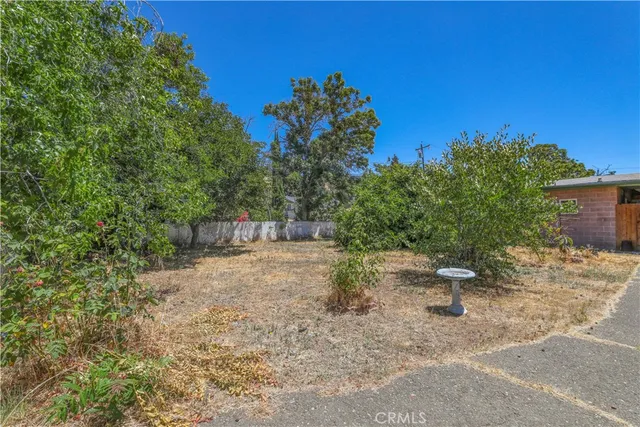 a backyard of a house with table and chairs under an umbrella