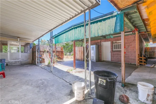a view of a patio with table and chairs under an umbrella