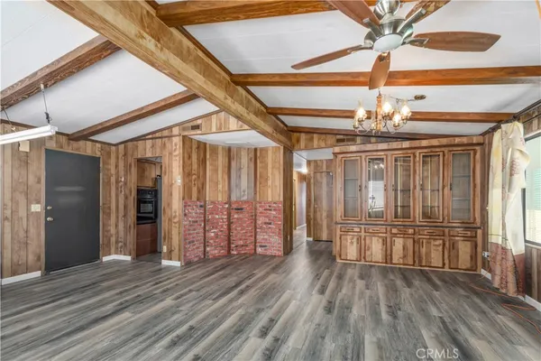 en empty room with wooden floor fan and windows