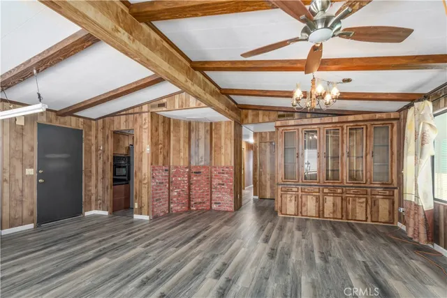 en empty room with wooden floor fan and windows