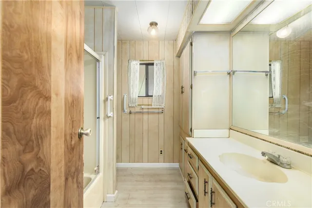 a bathroom with a granite countertop sink mirror and shower