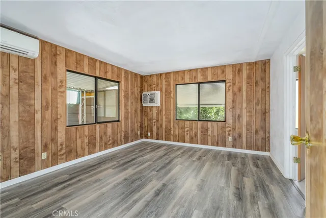 a view of wooden floor in an empty room with a window