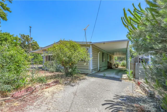 a view of a house with backyard and trees
