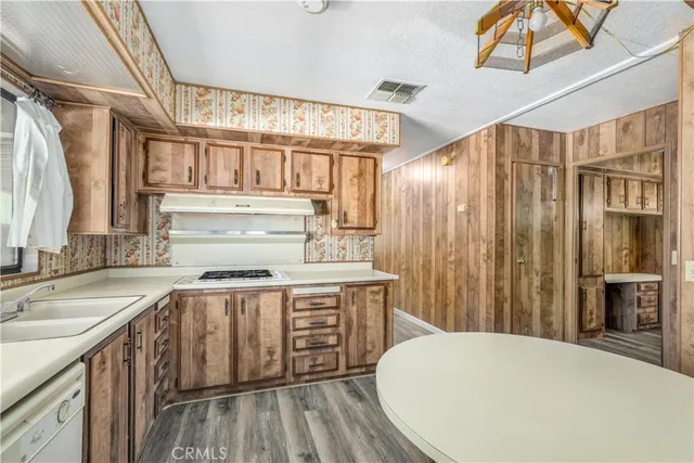 a kitchen with a sink a refrigerator and wooden cabinets